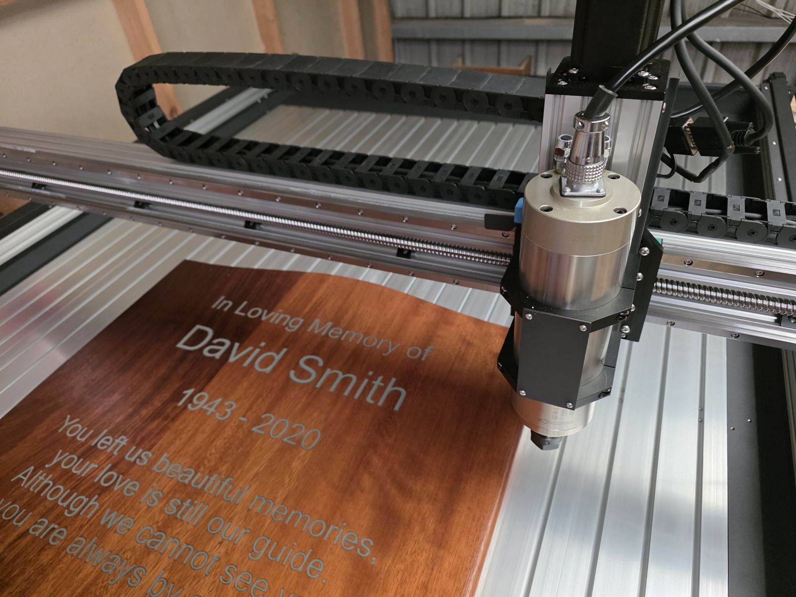 Lettering being CNC-carved into Iroko timber in our Belfast workshop