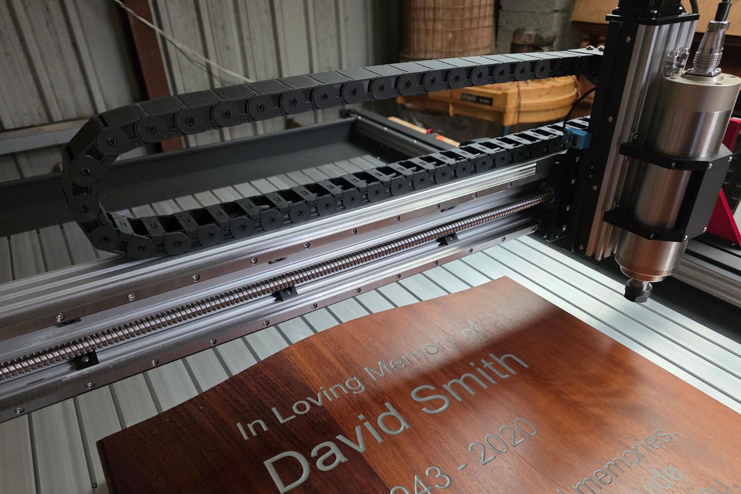 CNC machine carving a memorial in Iroko hardwood